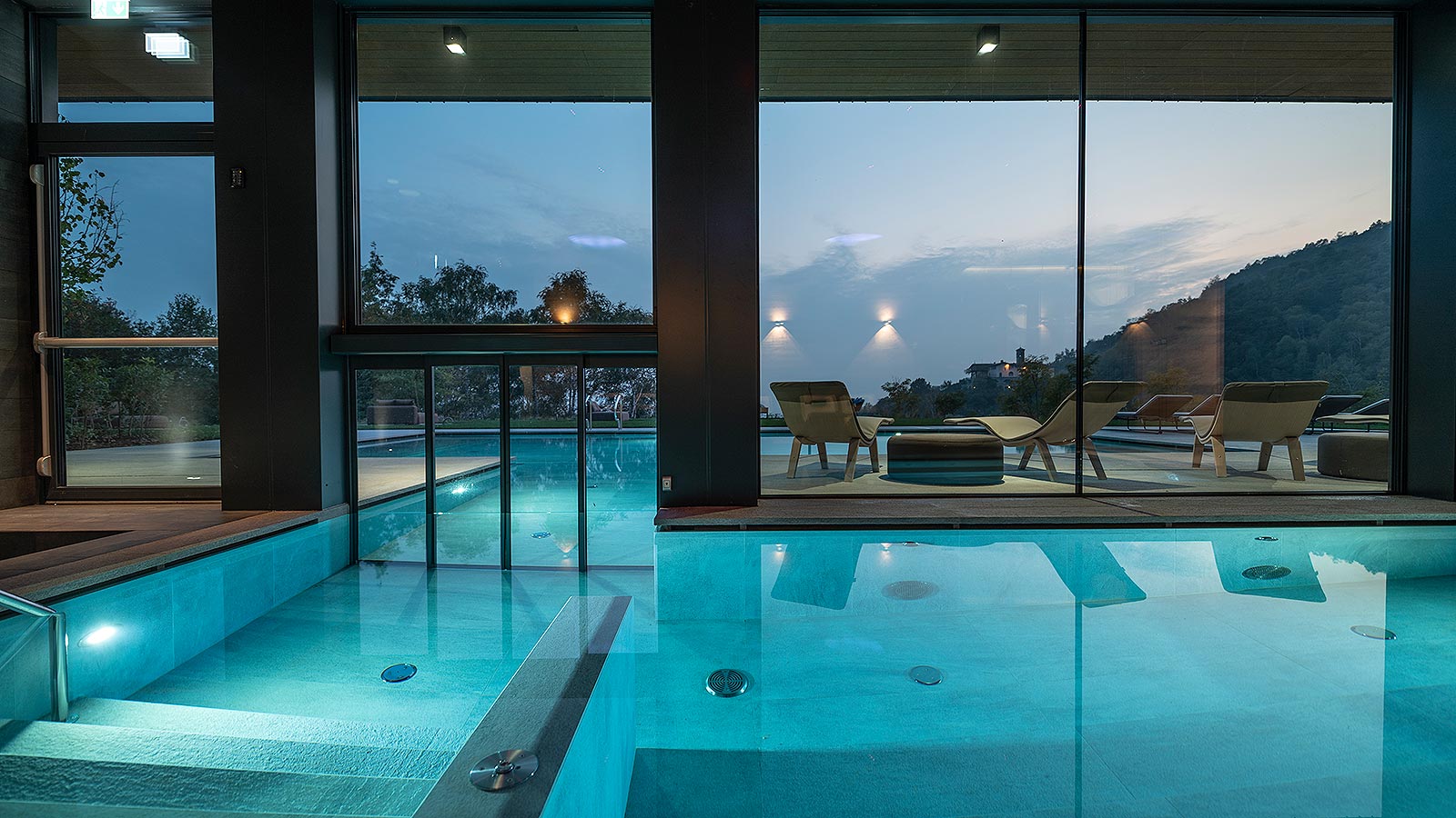 moderna piscina interna verso l'esterno realizzata da Spa Consulting